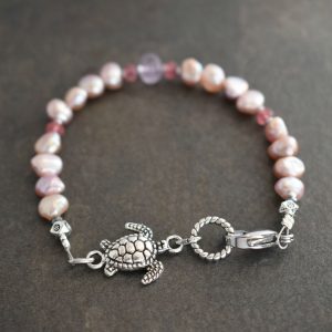 "Handmade Sea Turtle Bracelet with Pink Pearls and Amethyst Gemstones."