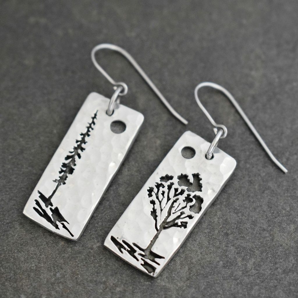 Silver long rectangles with a pine tree and aspen tree on them