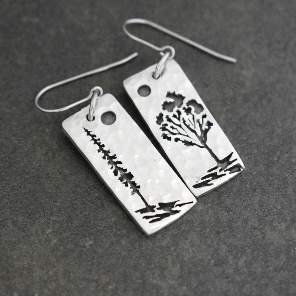 long rectangles with a pine tree and aspen tree on them