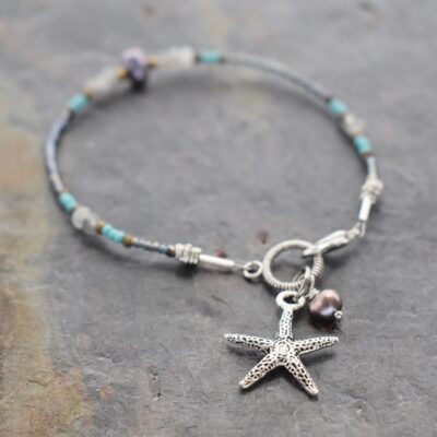 Thin beaded bracelet with natural labradorite gemstone, freshwater pearls with silver starfish charm. Thin beaded bracelet with gray gemstones, and pearls with silver 3d starfish charm