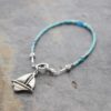 thin blue beaded bracelet with silver sail boat charm