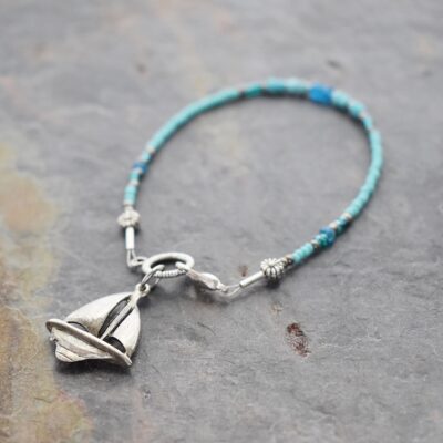 thin blue beaded bracelet with silver sail boat charm