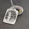 silver rectangle pendant with tree on it with marron and green gemstone charm