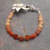 Beaded golds and dark oranges gemstone bracelet with silver Tigerlily flower clasp.
