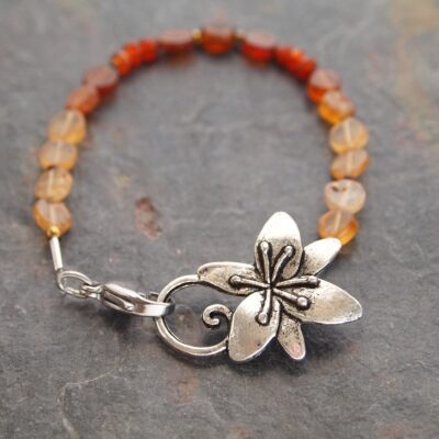 Beaded golds and dark oranges gemstone bracelet with silver Tigerlily flower clasp.