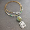 thin beaded gemstone necklace with a silver mountain goat pendant