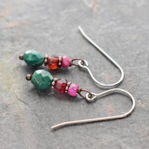 "Handmade gemstone earrings featuring faceted pink ruby, red garnet, and turquoise beads, copper spacers on silver wires."